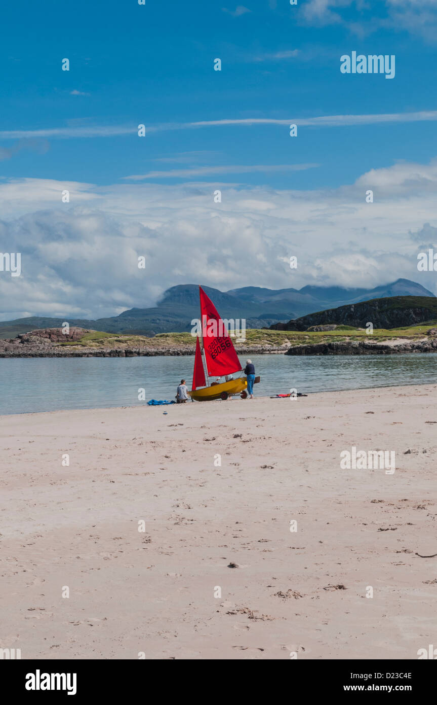 Yacht with red sails on beach Mellon Udrigle Gruinard Bay by Laide Ross & Cromarty Highland Scotland Stock Photo