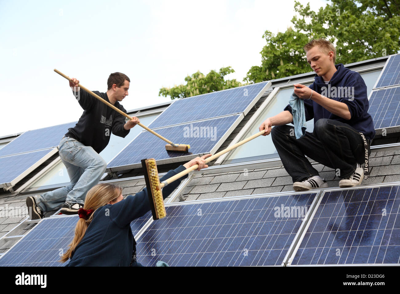 Apprentices Solar Berlin, Germany, apprentices cleans a solar panel Stock Photo - Alamy