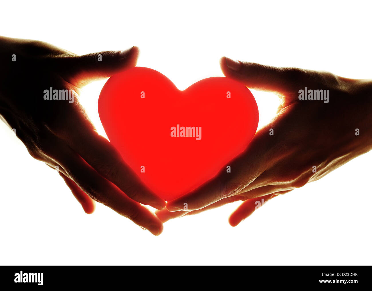 Two hands holding red heart, lightened for behind Stock Photo