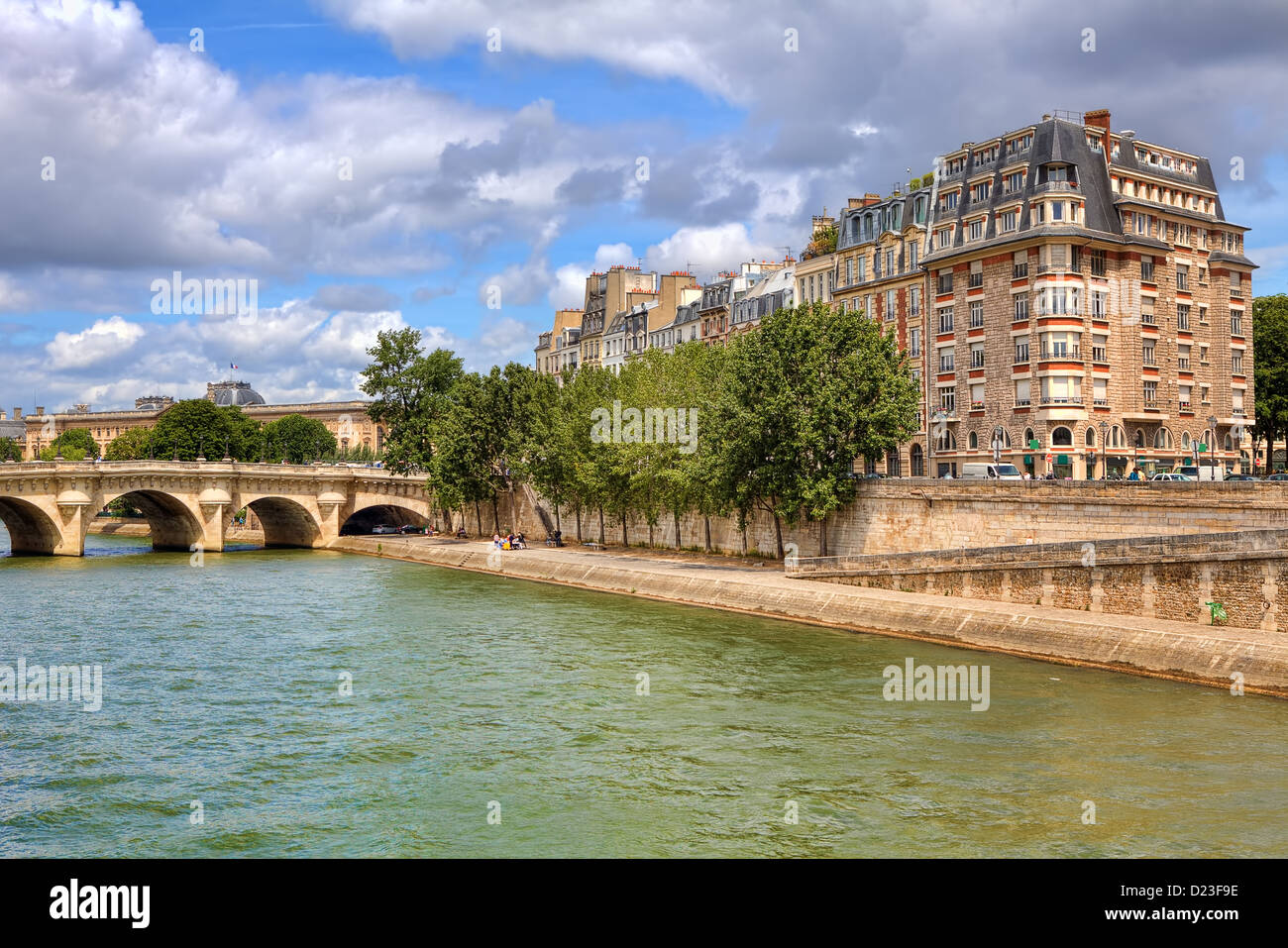 Urban view on bridge and promenade along Seine river and typical parisian building facade in Paris, France. Stock Photo