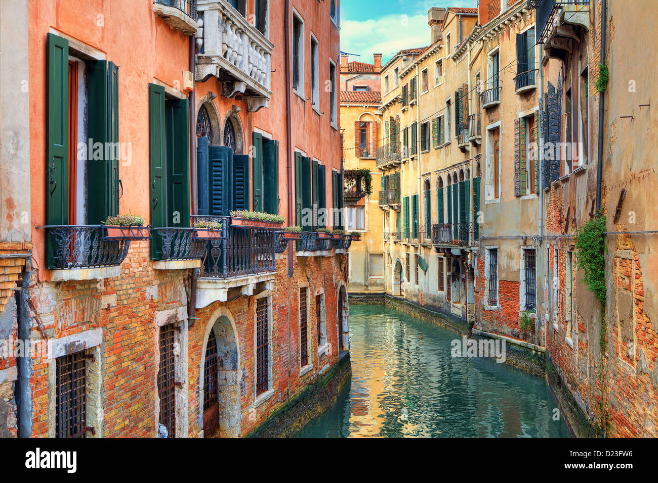 Narrow canal among old colorful brick houses in Venice, Italy Stock ...