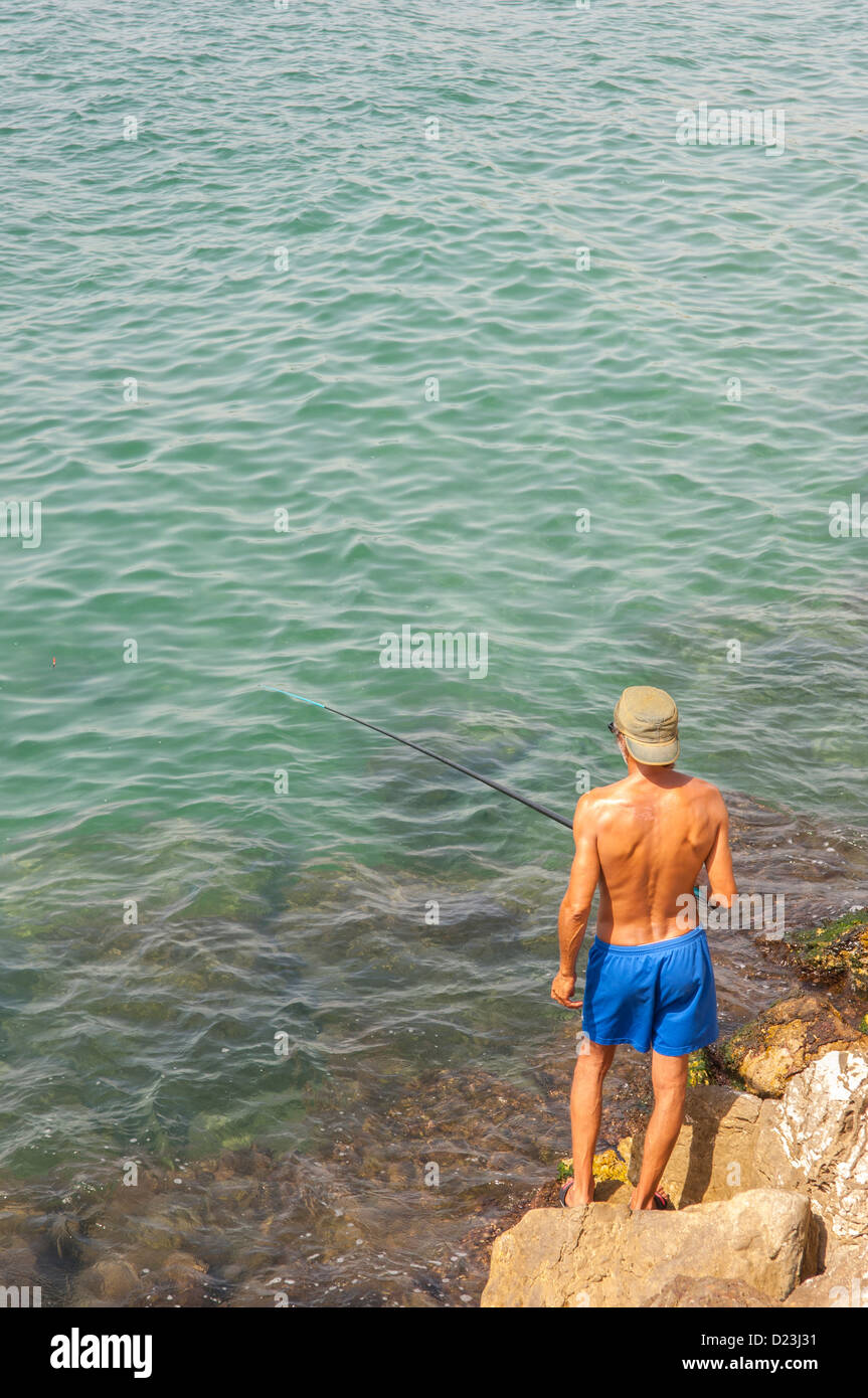 a-man-fishing-with-a-rod-at-the-fishing-port-of-cambrils-costa-dorada
