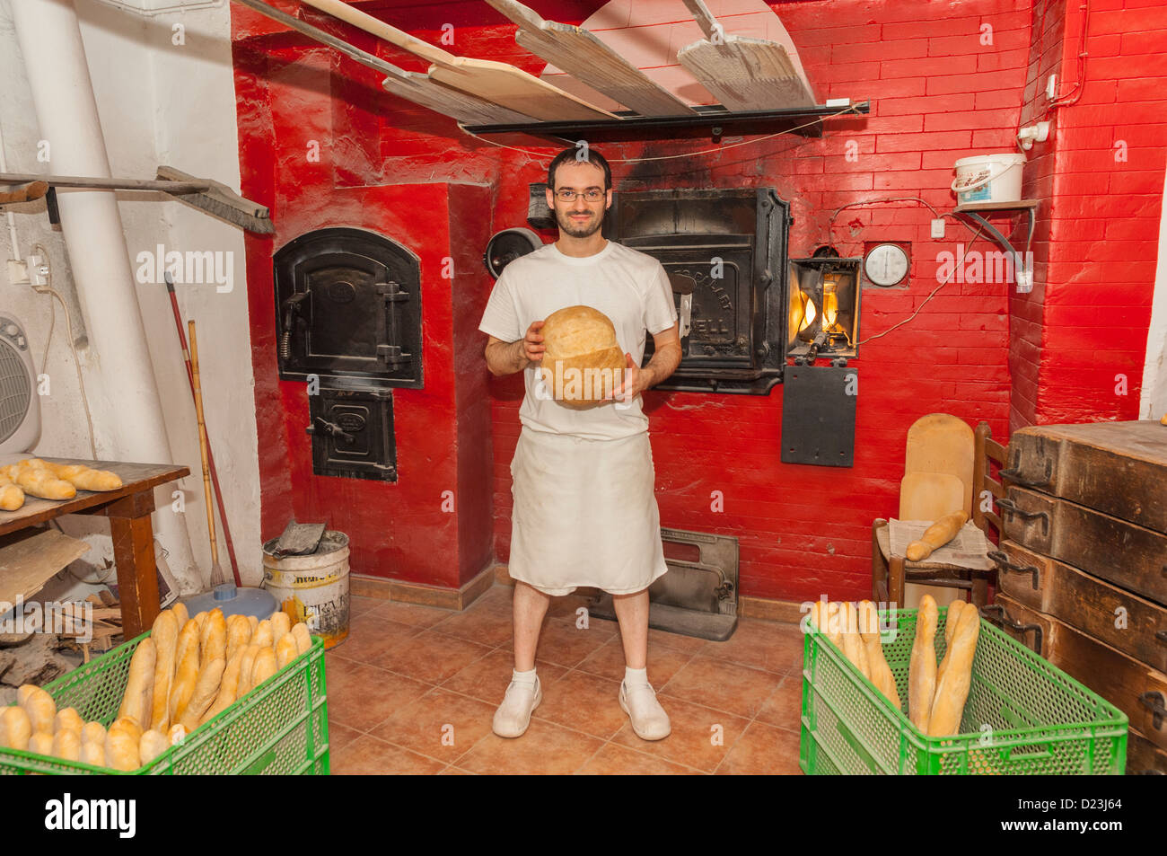 The owners son standing in front of the log fuelled oven in a traditional bakery in the old
