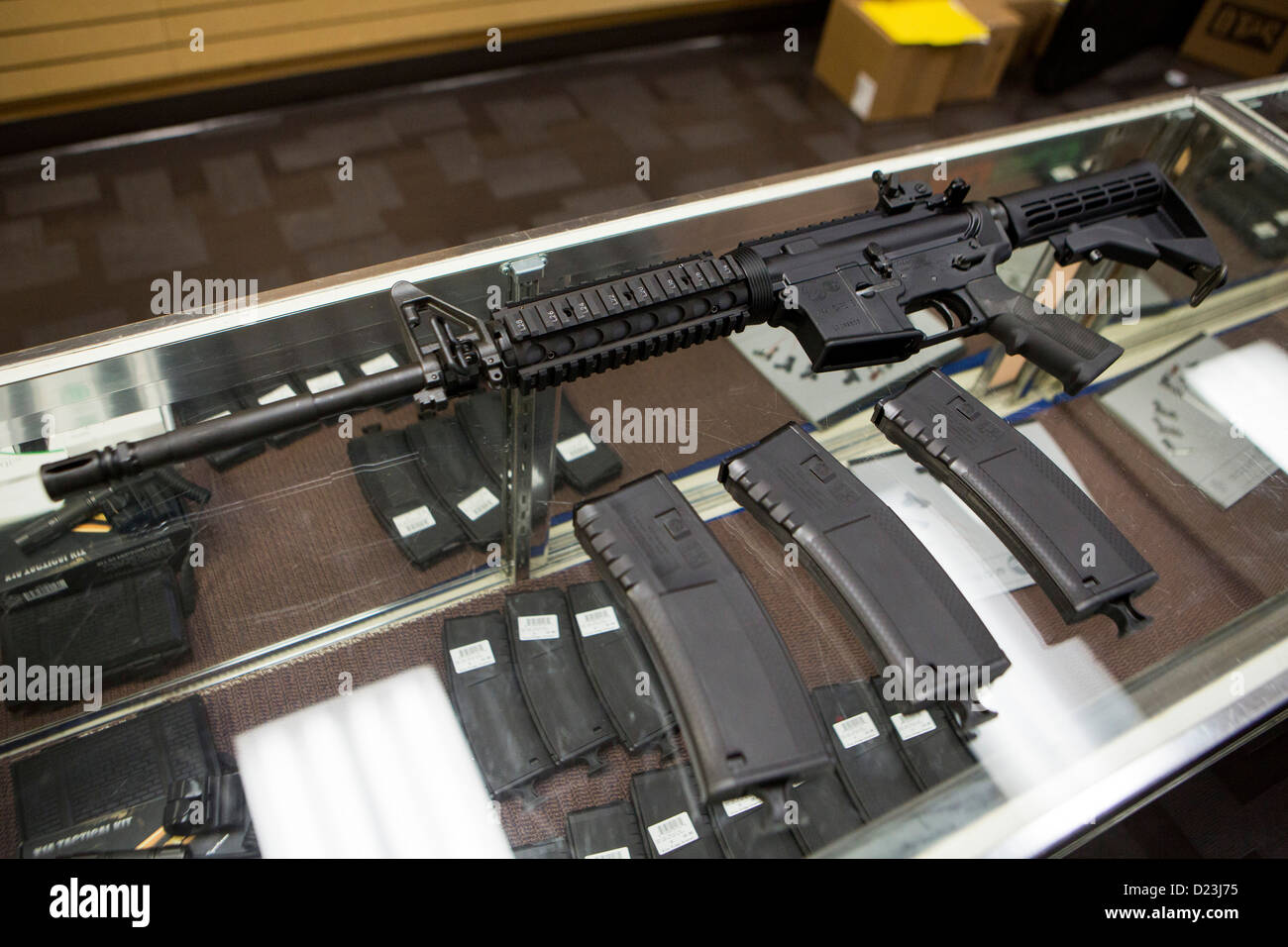 A Colt Defense M4A1 Carbine assault rifle on display at a gun shop with high capacity 30 round magazines.  Stock Photo
