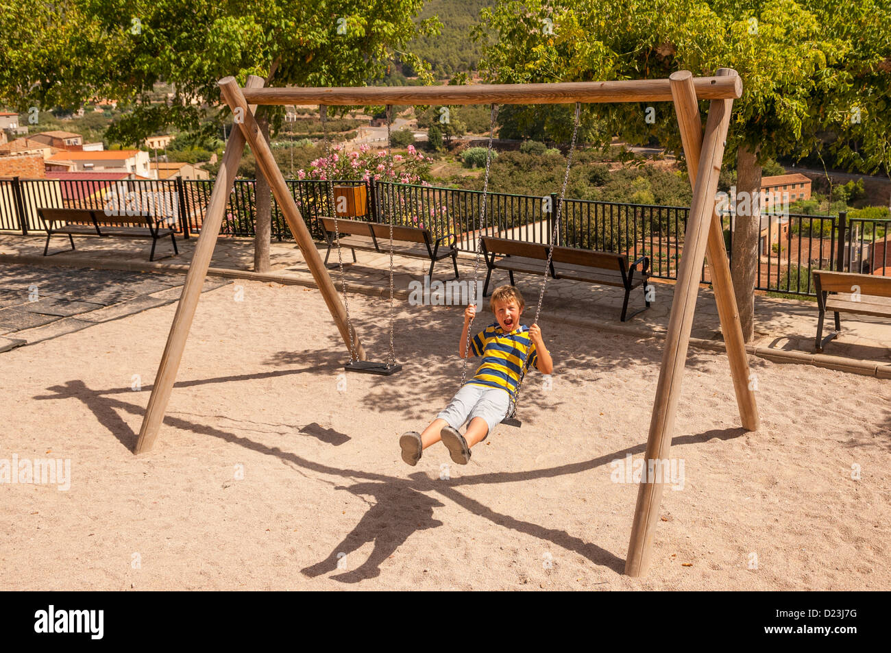 A boy playing on a swing in the old village of Pratdip , Costa Dorada , Spain Stock Photo