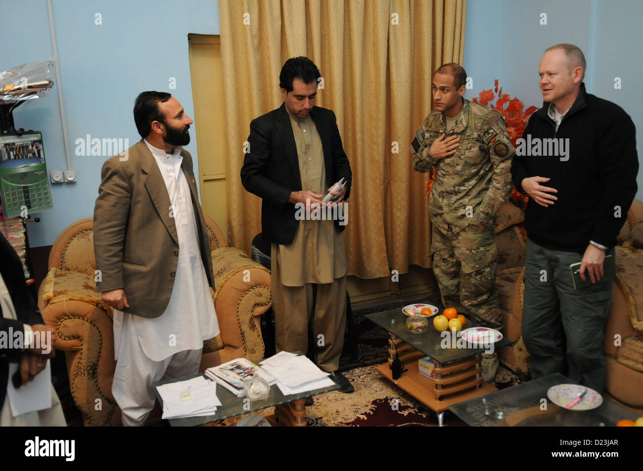 Ray Sudweeks, U.S. Department of State representative, right, and U.S. Navy Cmdr. Louis McCray, commanding officer Provincial Reconstruction Team (PRT) Farah, first from right, make departing comments at the conclusion of a meeting with Sa'ed Ahmad, mayor of Farah City, left, at the mayor's office, Jan. 13.  This was the first meeting with the mayor since he took office, and was an opportunity for leaders to discuss governance and socioeconomic development issues and initiatives in the municipality.  PRT Farah's mission is to train, advise, and assist Afghan government leaders at the municipal Stock Photo