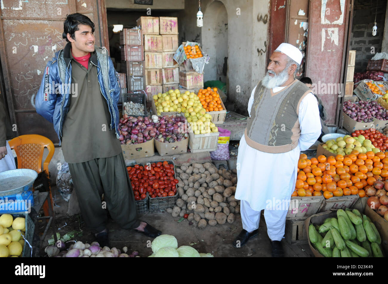 A produce shop owner, right, and his employee share a conversation in Farah City, Jan. 13.  Provincial Reconstruction Team (PRT) Farah liaisons visited a nearby bank to discuss small business development and growth initiatives in Farah.  PRT Farah's mission is to train, advise, and assist Afghan government leaders at the municipal, district, and provincial levels in Farah province Afghanistan.  Their civil military team is comprised of members of the U.S. Navy, U.S. Army, the U.S. Department of State and the U.S. Agency for International Development (USAID).  (U.S. Navy photo by Lt. j.g. Matth Stock Photo