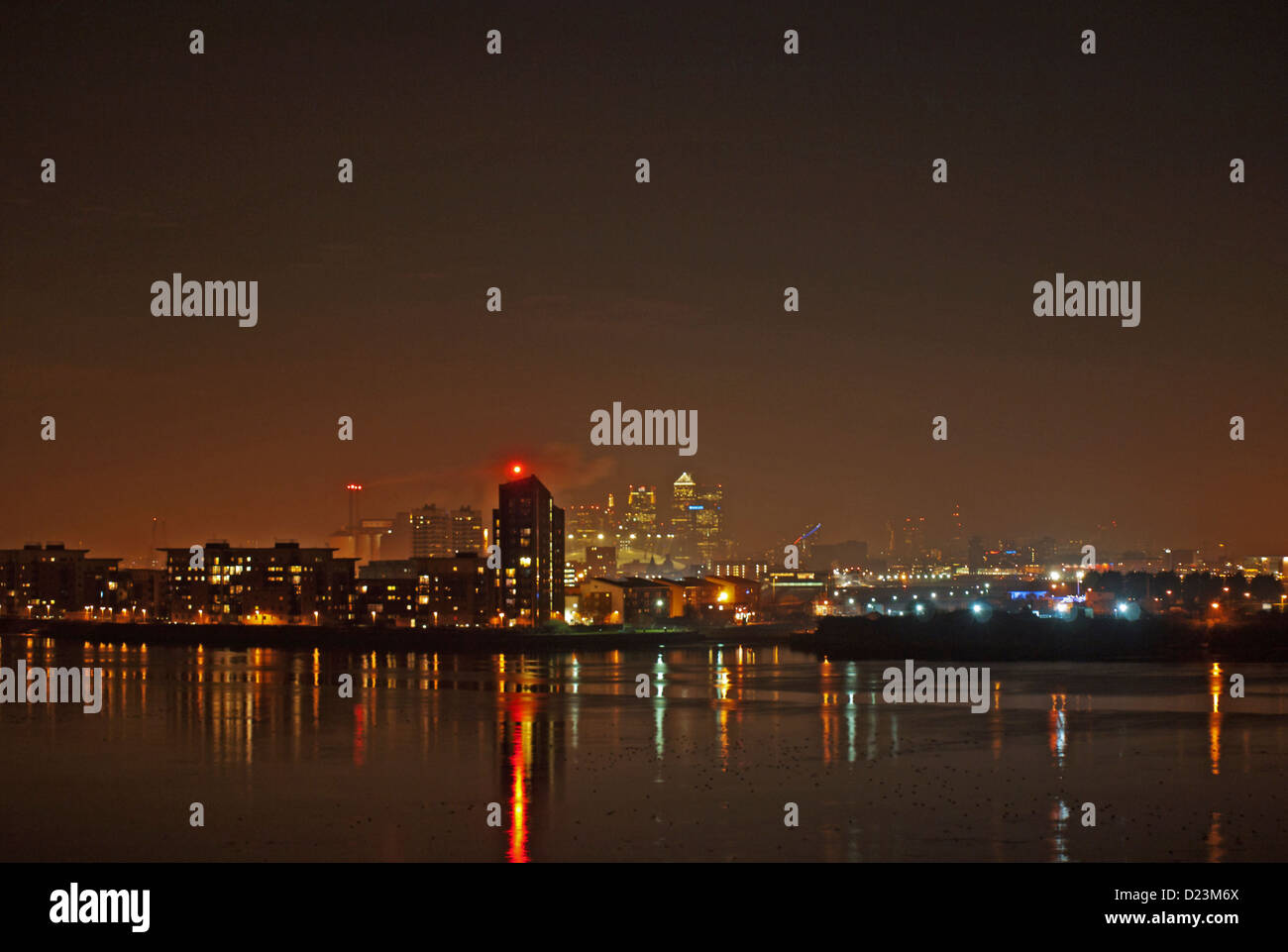 Night view of the Shard, Canary Wharf and the 02 Arena from Thamesmead SE London showing riverside apartments and River Thames. Stock Photo