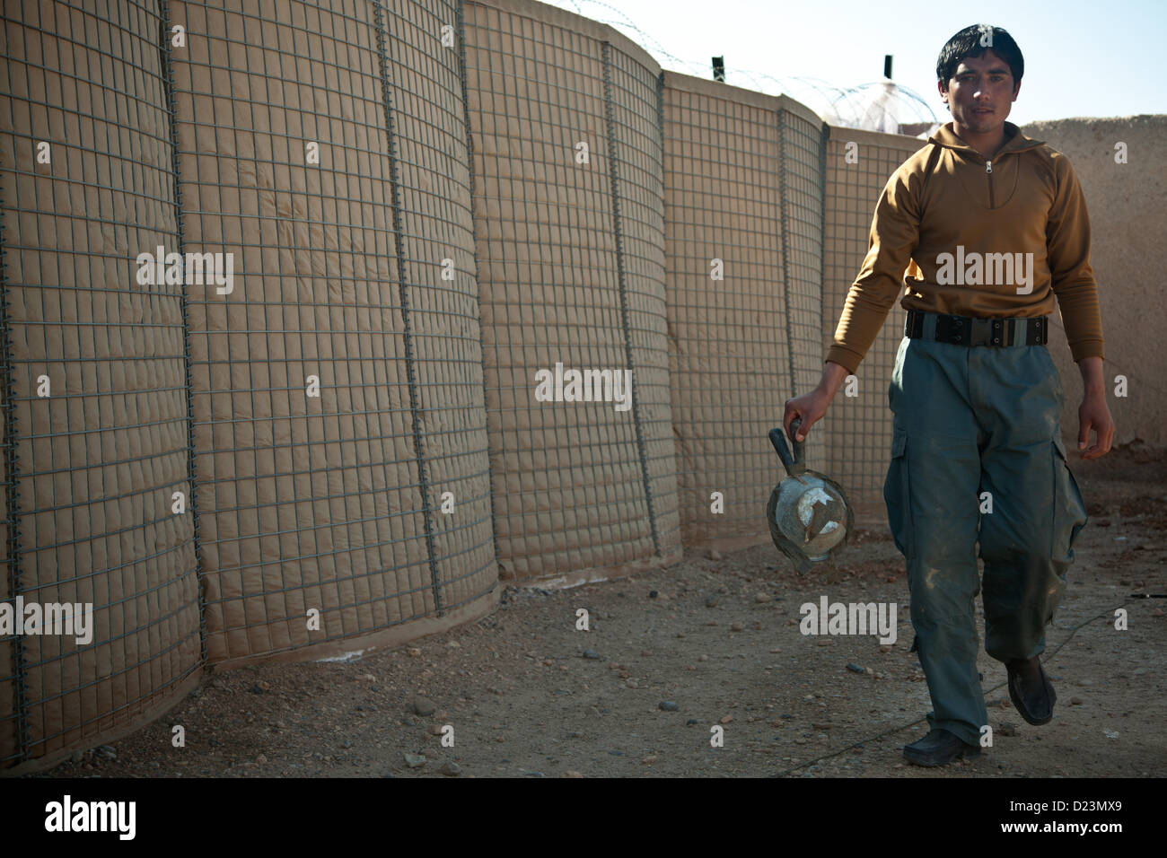 An Afghan National Policeman walks with a notional improvised explosive devices during training with fellow Afghan Nationa Security Force members in Farah province, Afghanistan, Jan. 13, 2013. Afghan National Security Forces have been taking the lead in security operations, with coalition forces as mentors, to bring security and stability to the people of the Islamic Republic of Afghanistan. (U.S. Marine Corps photo by Sgt. Pete Thibodeau/Released) Stock Photo