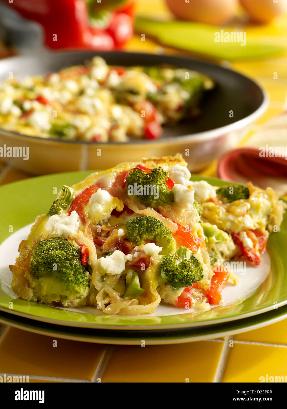 Caramelized onion, red bell pepper, broccoli and cheese frittata in a kitchen setting Stock Photo