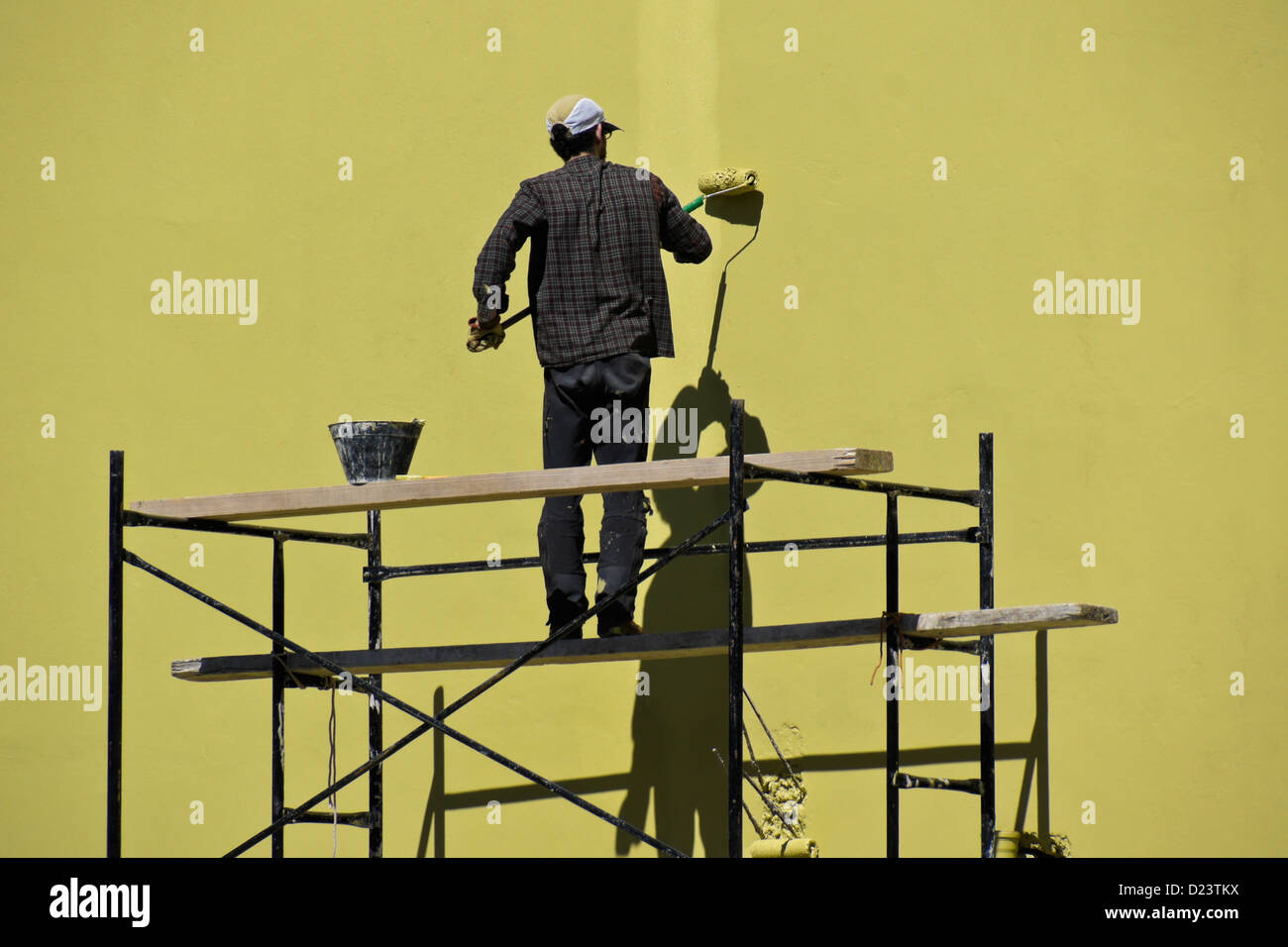 Man rolling paint onto exterior building wall Stock Photo Alamy