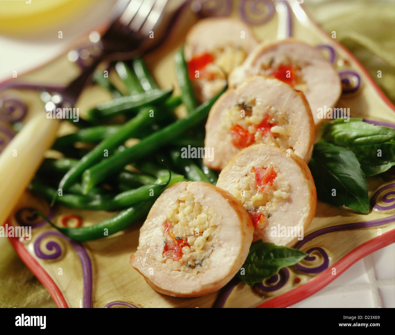 Slices of chicken stuffed with rice and served with green beans Stock Photo