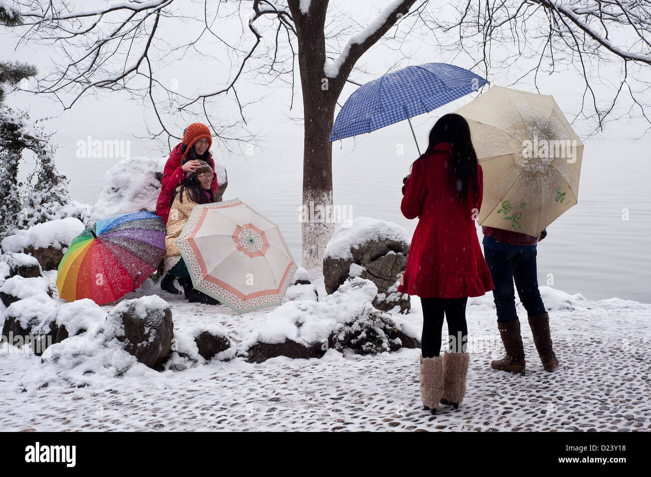 A group of Chinese girls pose for photographs in the snow beside West Lake, Hangzhou Stock Photo