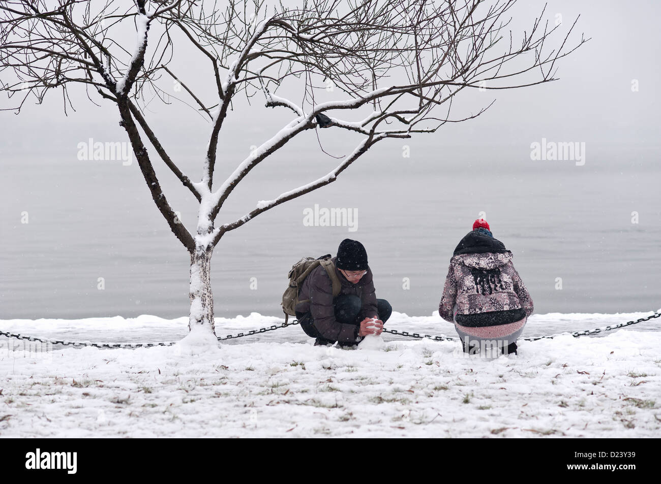 Young Chinese couple playing in the winter snow beside West Lake, Hangzhou Stock Photo