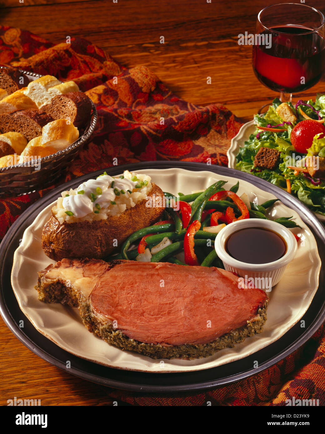 Prime Rib Dinner With A Loaded Baked Potato Vegetables Salad And A Glass Of Red Wine Stock Photo Alamy