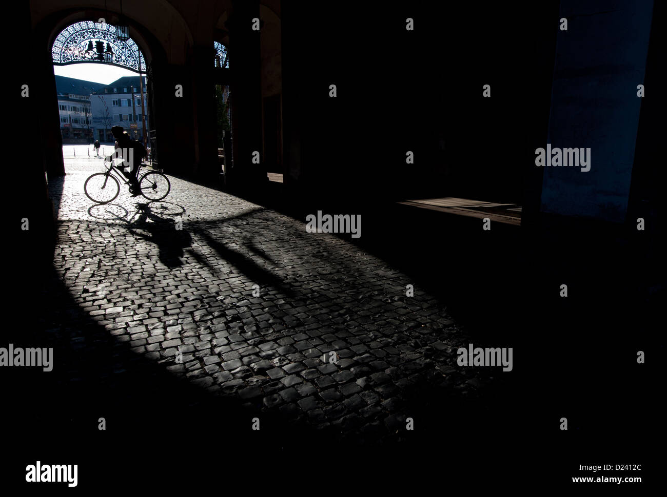 Long shadows are cast onto cobblestones by a gate of the palace in Darmstadt, Germany, 11 January 2013. The sun came out in southern Hesse for the first time in weeks. Photo: Boris Roessler Stock Photo