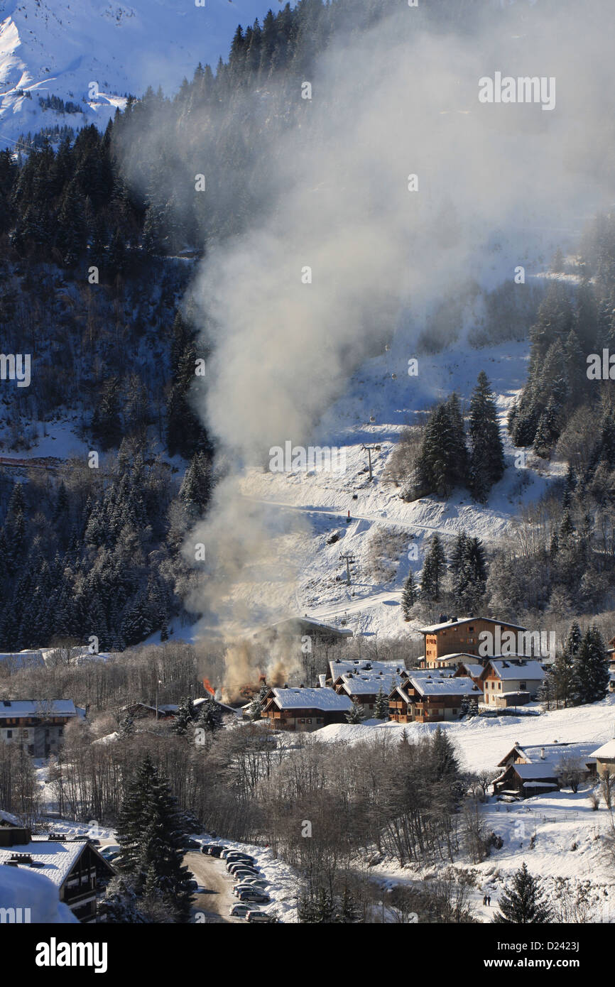 Smoke from a barn fire rising above ski resort Stock Photo