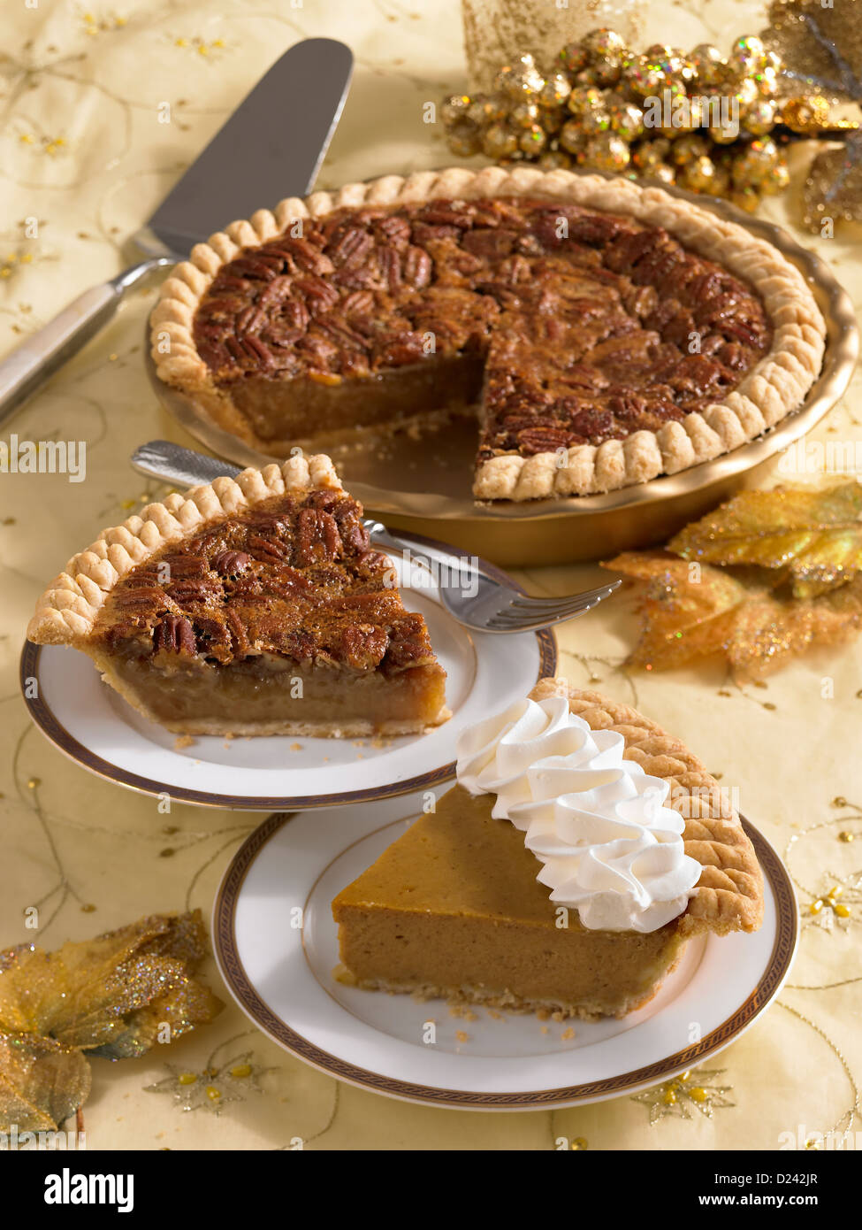 Pecan and pumpkin pie slice with a whole pecan pie if a festive holiday setting Stock Photo