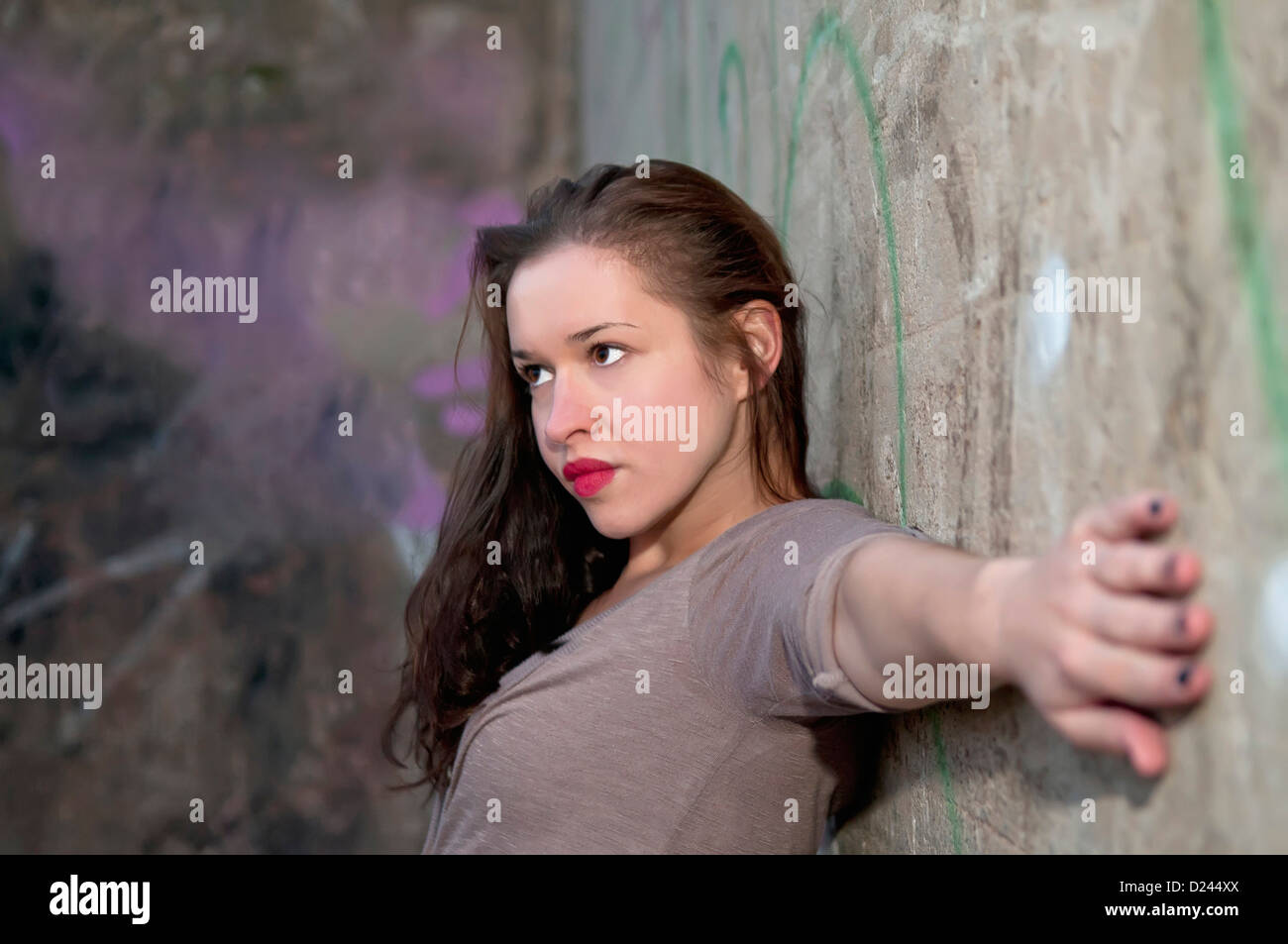 Germany, Young woman with arms outstretched on wall Stock Photo