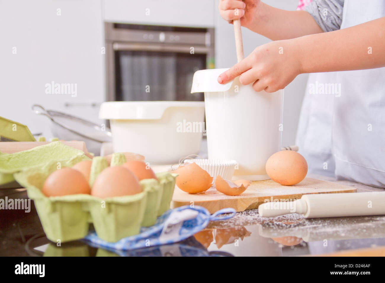 Germany, Boy stirring dough in bowl Stock Photo