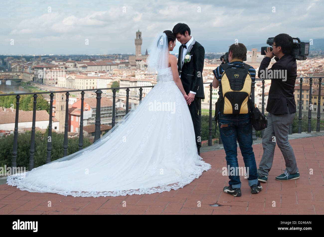 Chinese couple bride and groom pose for wedding photographs and video on terrace of Piazzale Michelangelo Florence Firenze Italy Stock Photo
