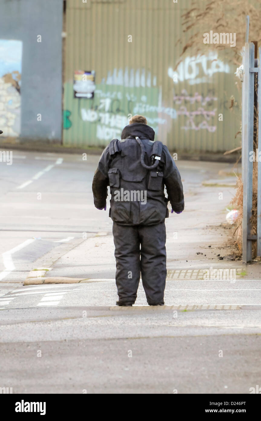 Belfast, Northern Ireland, UK. 14th January 2013.   ATO from the RLC EOD 11th Squadron (The Bomb Squad) wearing most of his bomb proof suit, examines the scene around a suspect device before advancing to defuse it. Stock Photo