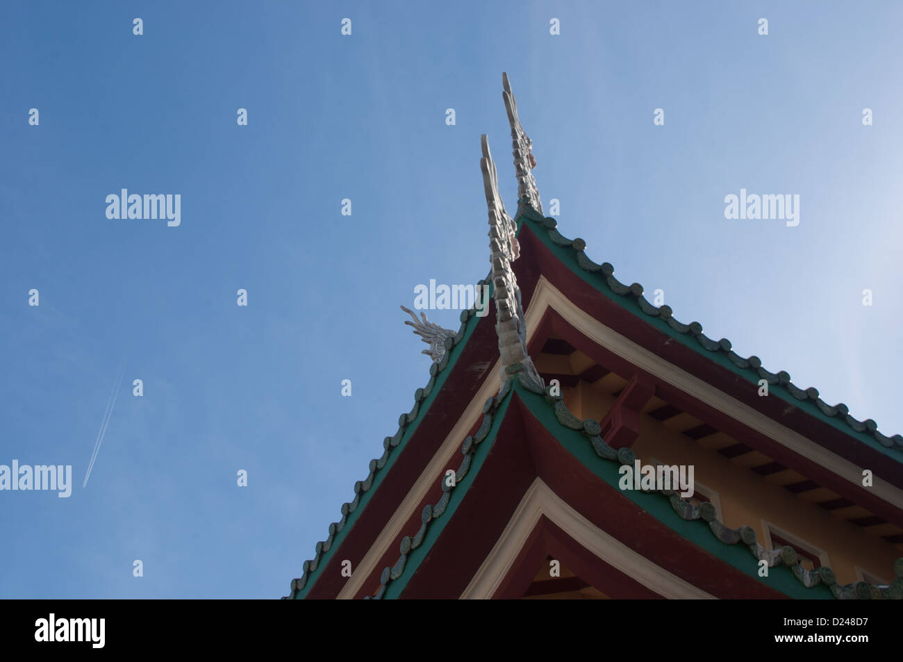 View of the edge of a temple at Linh Ung Pagoda with the contrail from an aircraft Da Nang Vietnam Stock Photo