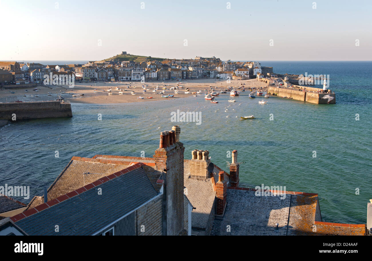 St Ives harbour and town viewed over rooftops in evening light. Stock Photo
