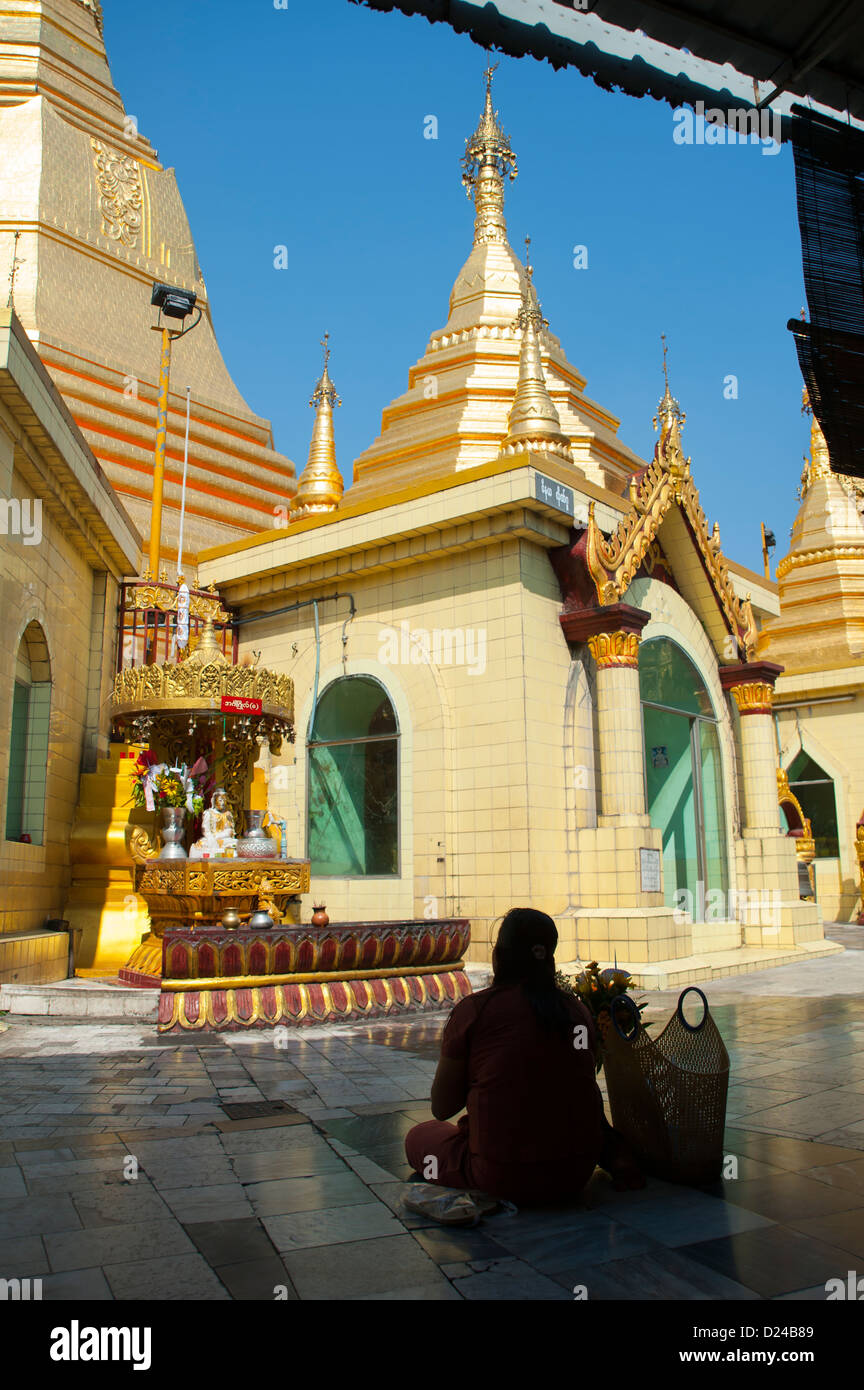 A Burmese woman sits in prayer/meditation at Sule Pagoda, Yangon, Burma Stock Photo