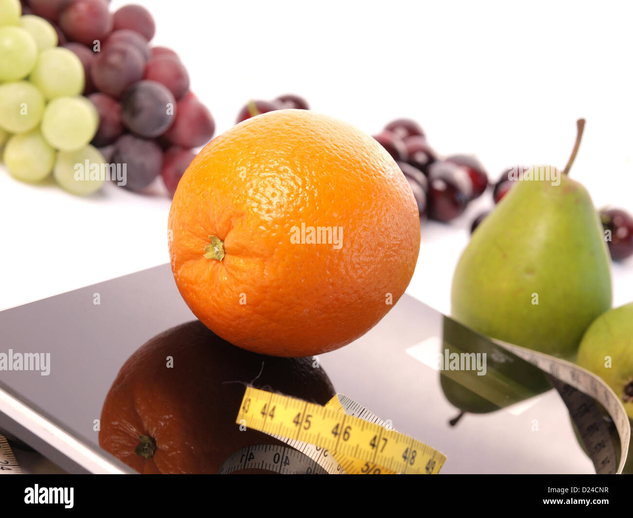 Orange on a scale with fresh fruits Stock Photo Alamy