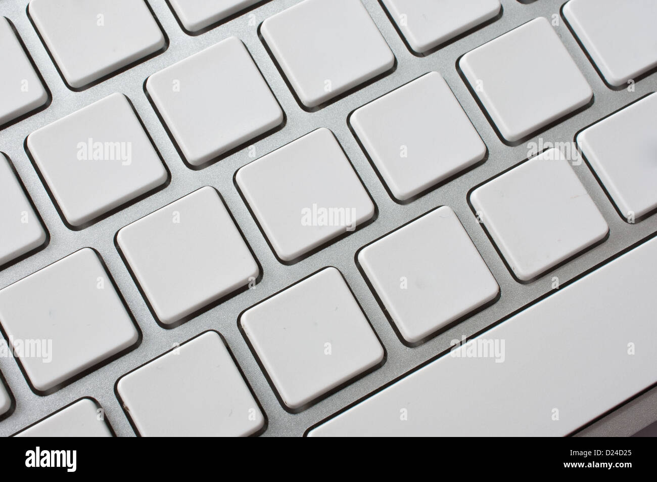 Close up image of a modern stylish aluminium white computer keyboard with blank keys for your own idea. Stock Photo