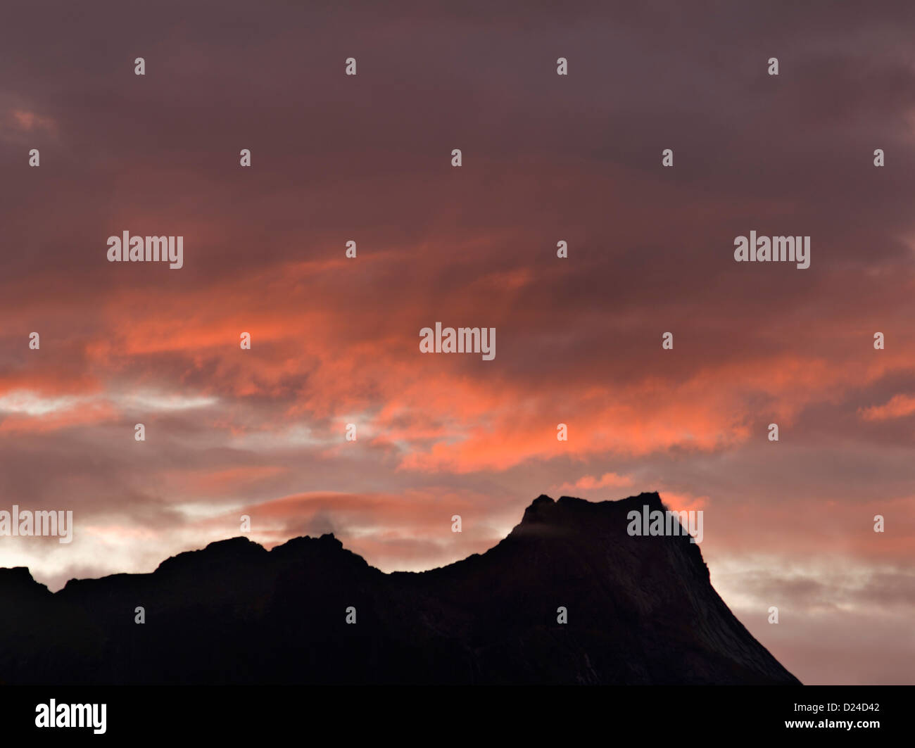 Rocky peaks of the Reine district in the Lofoten isles outlined against a sunset sky, northern Norway Stock Photo