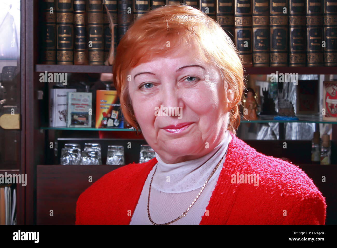 senior woman posing against bookshelf Stock Photo Alamy