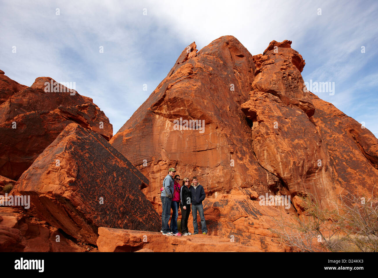 tourists pose in front of petroglyphs on atlatl large rock valley of fire state park nevada usa Stock Photo