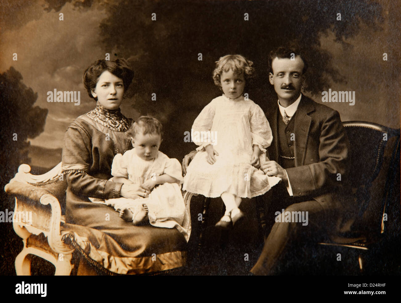 Family history, Edwardian studio portrait of parents and two young children in dresses Stock Photo