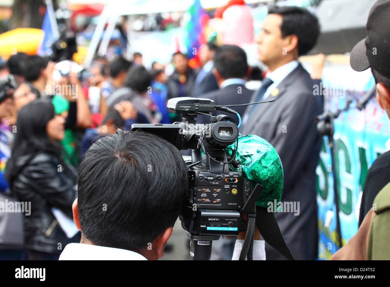 LA PAZ, BOLIVIA, 14th January. A bag of coca leaves hangs on a TV camera while the camerman covers an event to celebrate Bolivia rejoining the 1961 UN Single Convention on Narcotic Drugs. Bolivia formally withdrew from the Convention in 2011 and had been campaigning for clauses banning traditional uses of the coca leaf to be removed. By the 11th January 2013 deadline only 15 countries (less than the 62 required to block the proposal) had registered an objection to Bolivia rejoining the Convention with special dispensations. Stock Photo