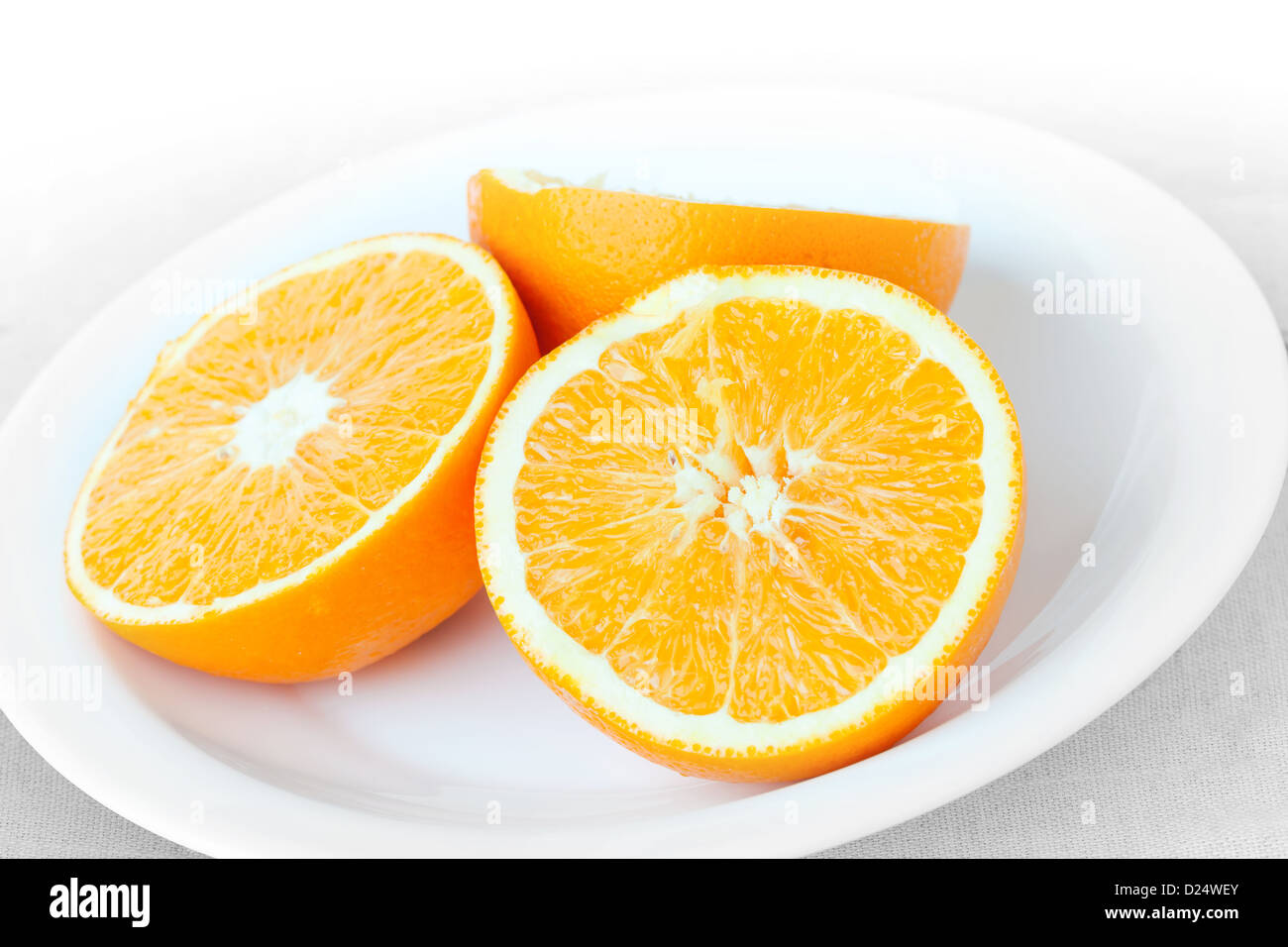 Sliced fresh orange fruit on a white plate Stock Photo