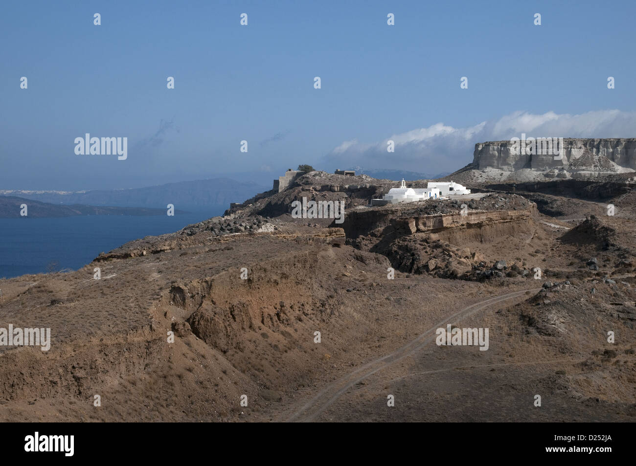 View volcanic coastal landscape with white-washed Orthodox church Balos Bay Santorini Cyclades Aegean Sea Greece September Stock Photo