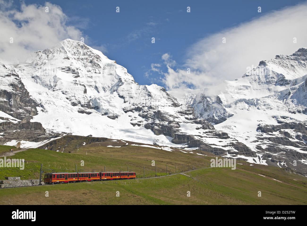Jungfraubahn train leaving Kleine Scheidegg towards Jungfraujoch, Monch mountain in background, Bernese Alps, Switzerland, June Stock Photo