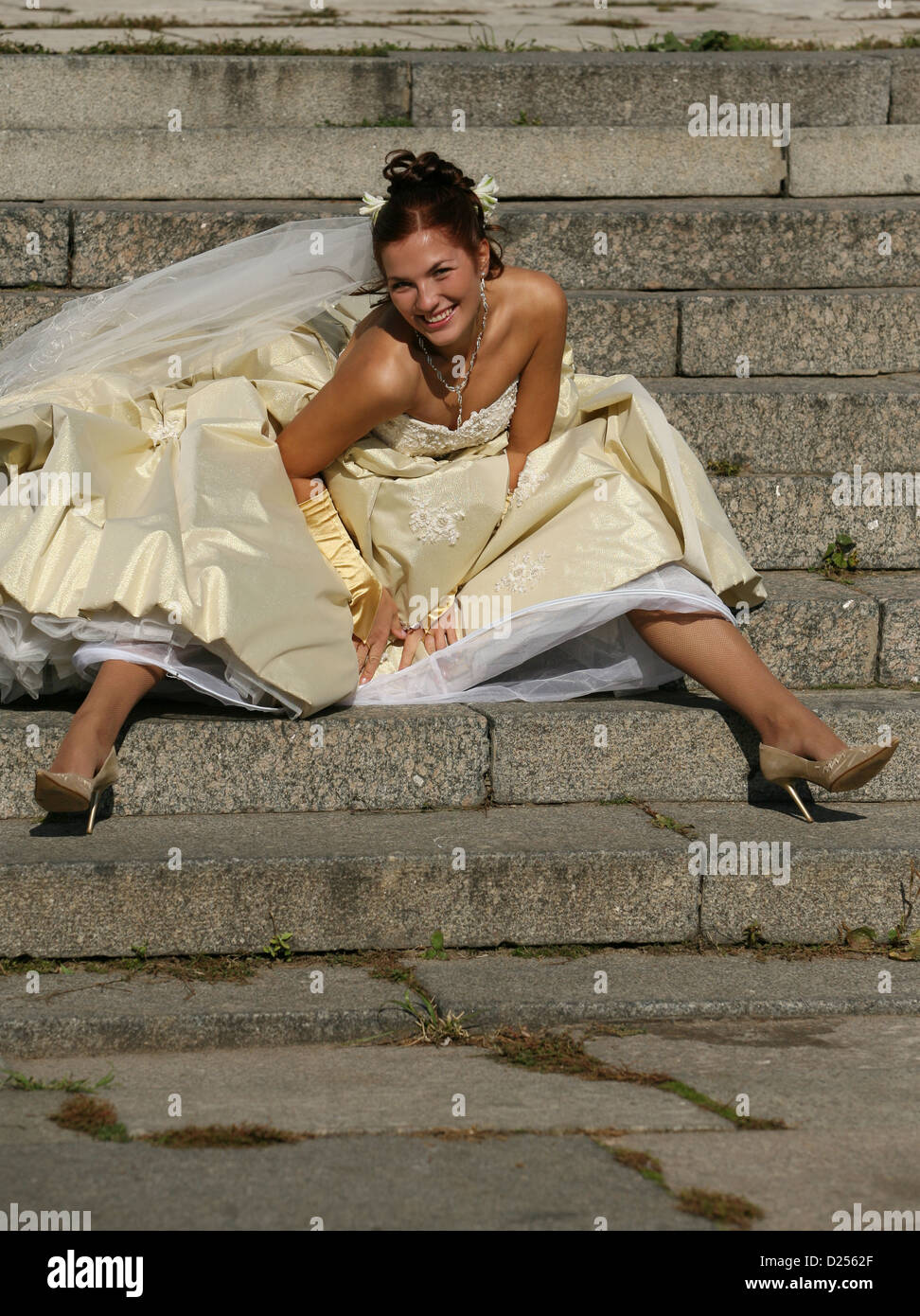 The beautiful bride sitting on a stone ladder Stock Photo - Alamy