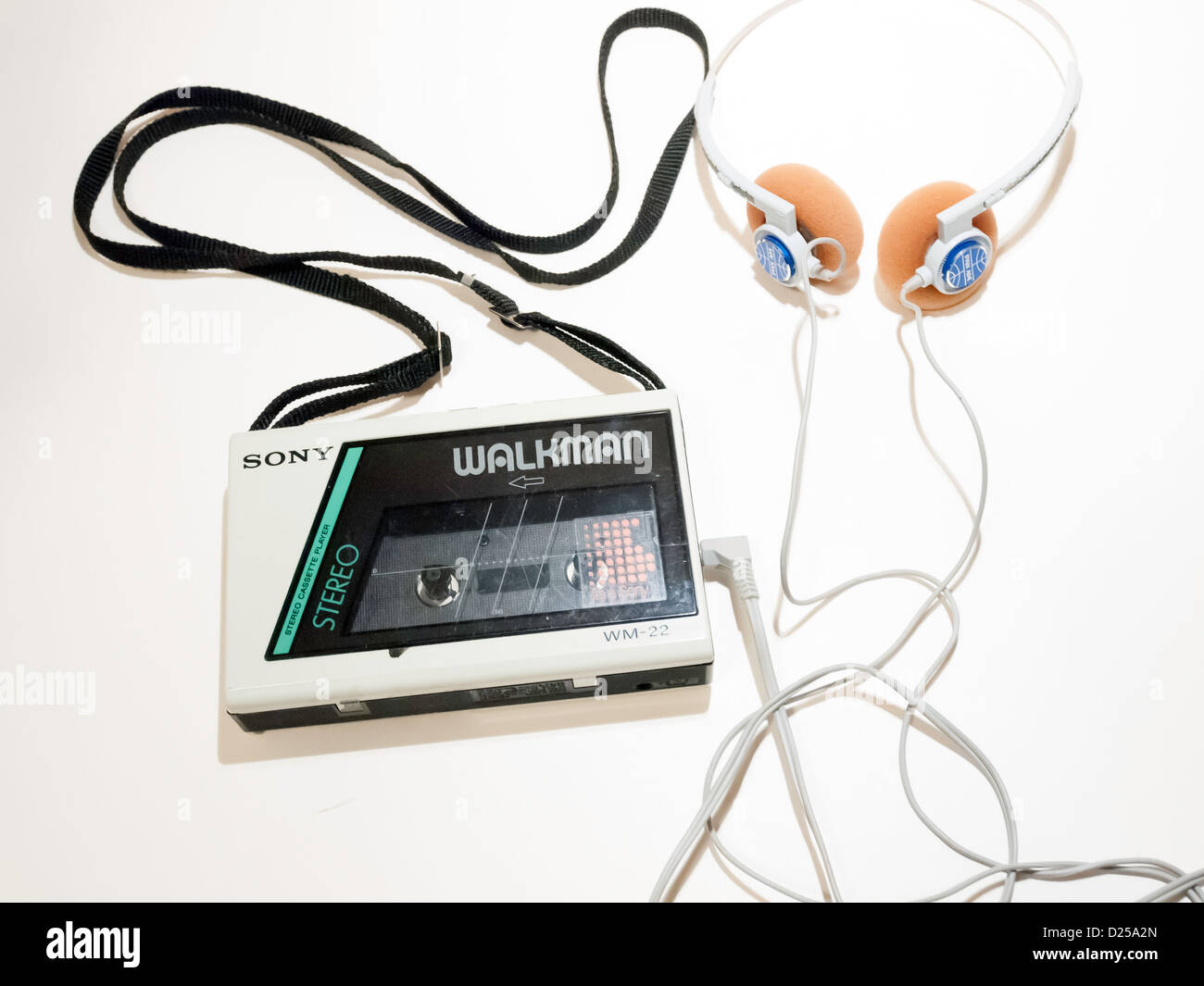 A 1980's Sony Walkman WM22 budget model personal stereo cassette player with a pair of Pan Am earphones on a white background Stock Photo