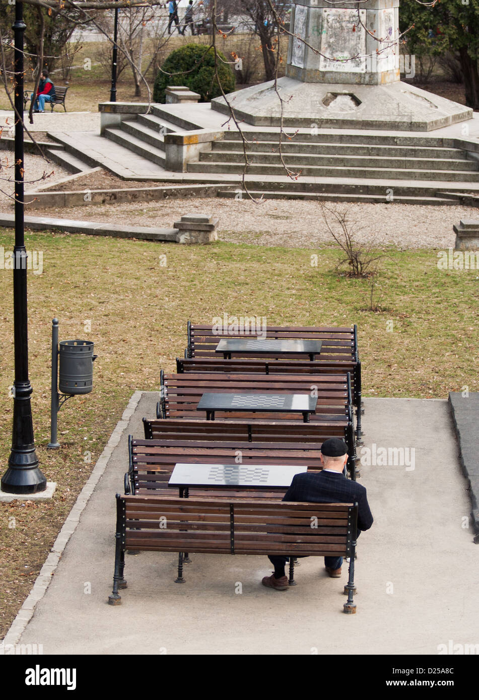 An old man sitting on a bench in a park, autumn afternoon Stock Photo ...
