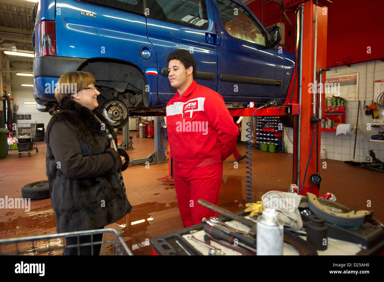 Djamil (15 years old), participant of the school pilot project 'Productive Learning,' talks with Saxony's Culture Minister Brunhild Kurth during her visit to a mechanic's garage (ATU-Autoteile Unger) in Dresden, Germany, 14 January 2013. The project for pupils who are in danger of not finishing high school, is being offered permanently in Saxony, according to Saxony's Culture Minister Kurth on Monday. At the moment around 200 pupils in the 8th and 9th year spend two days a week doing an internship of their own choosing. Photo: Arno Burgi Stock Photo