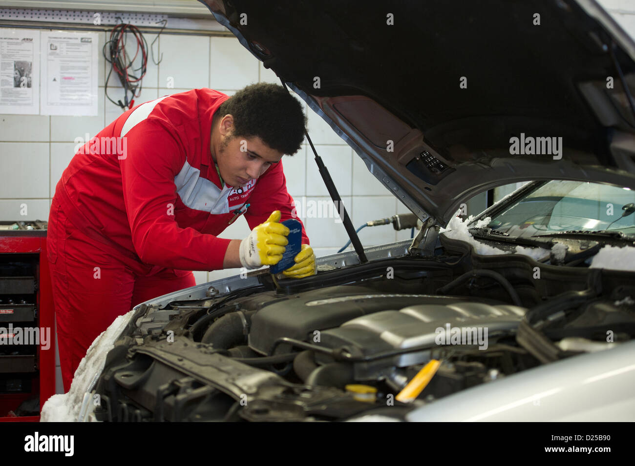 Djamil (15 years old), participant of the school pilot project 'Productive Learning,' checks a vehicle's antifreeze content as part of his internship at a mechanic's garage in Dresden, Germany, 14 January 2013. The project for pupils who are in danger of not finishing high school, is being offered permanently in Saxony, according to Saxony's Culture Minister Kurth on Monday. At the moment around 200 pupils in the 8th and 9th year spend two days a week doing an internship of their own choosing. Photo: Arno Burgi Stock Photo