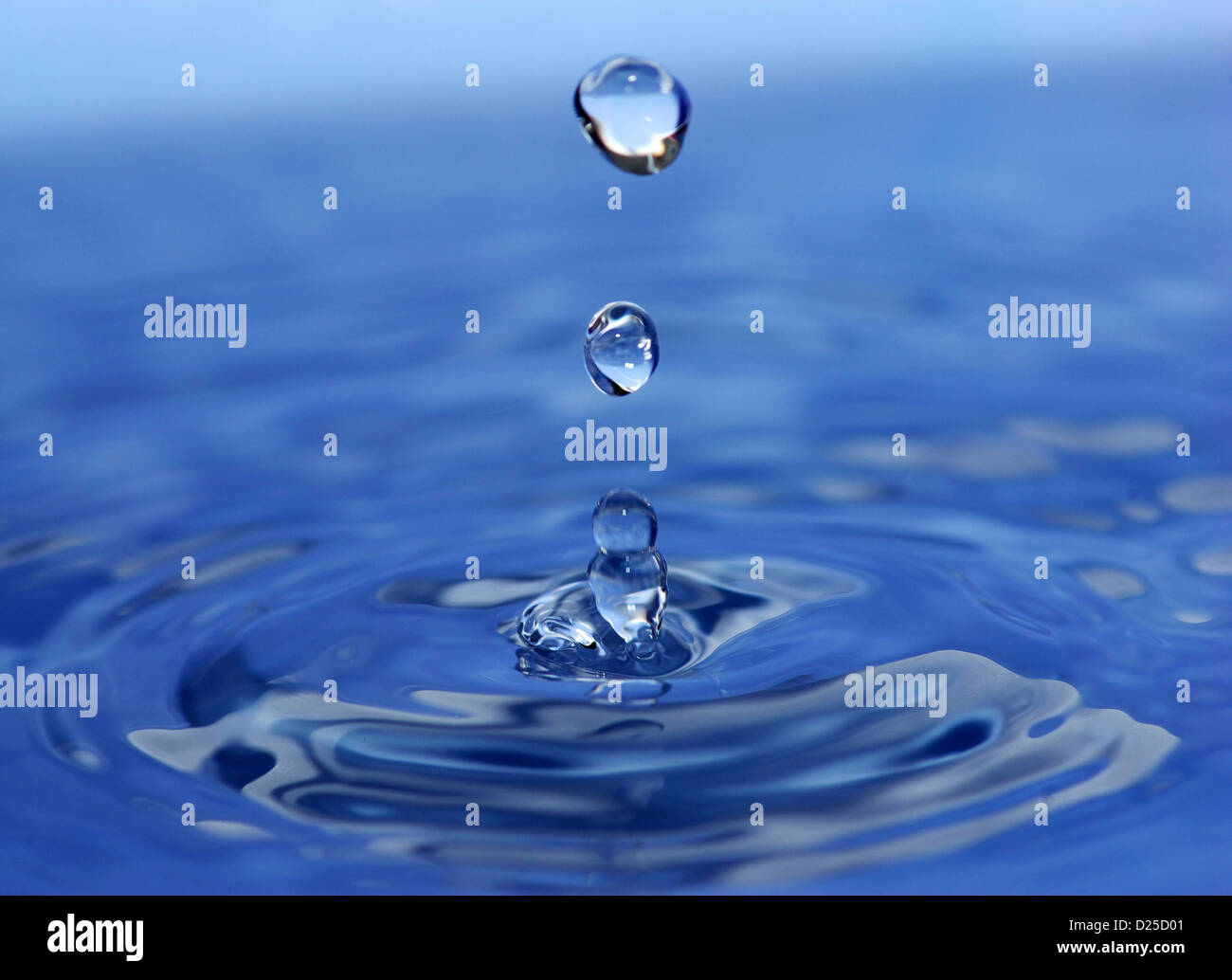 The round transparent drop of water falls downward Stock Photo