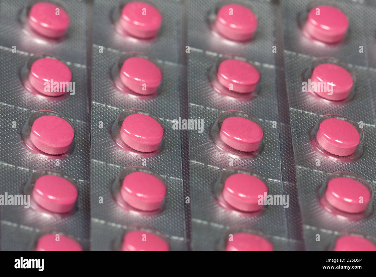 Several small packets of pink pills stacked Stock Photo Alamy