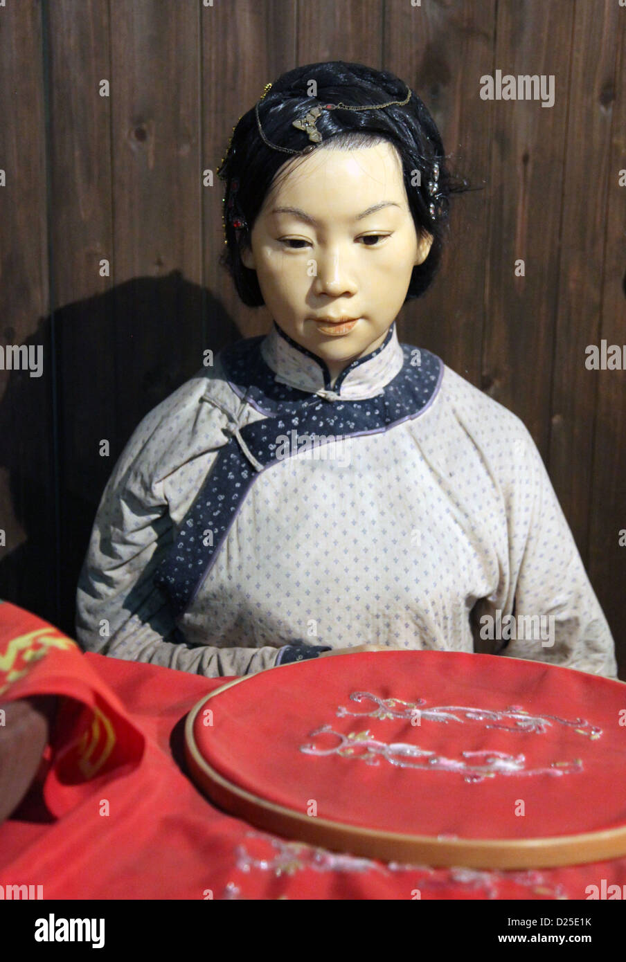 It's a photo of a Close up of a wax model at the museum of history. They are Chinese people for