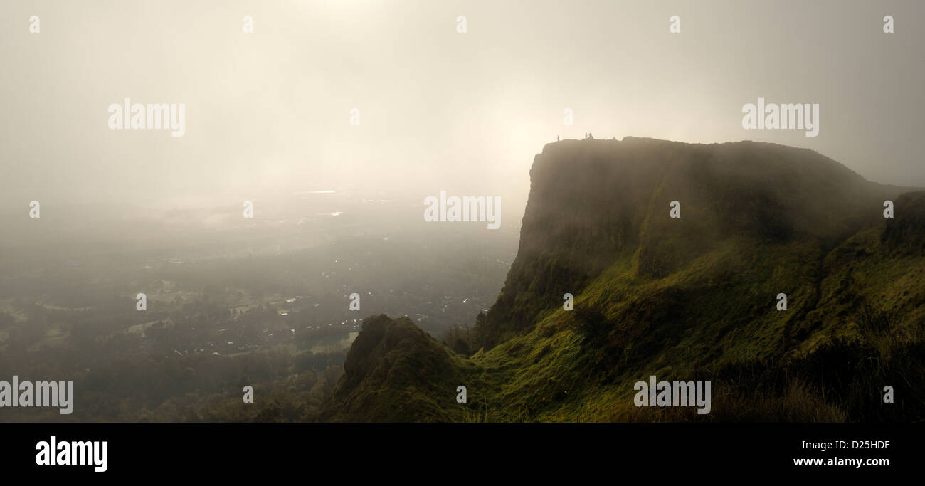 People silhouetted on misty morning standing on top of Cavehill with Belfast in background Stock Photo