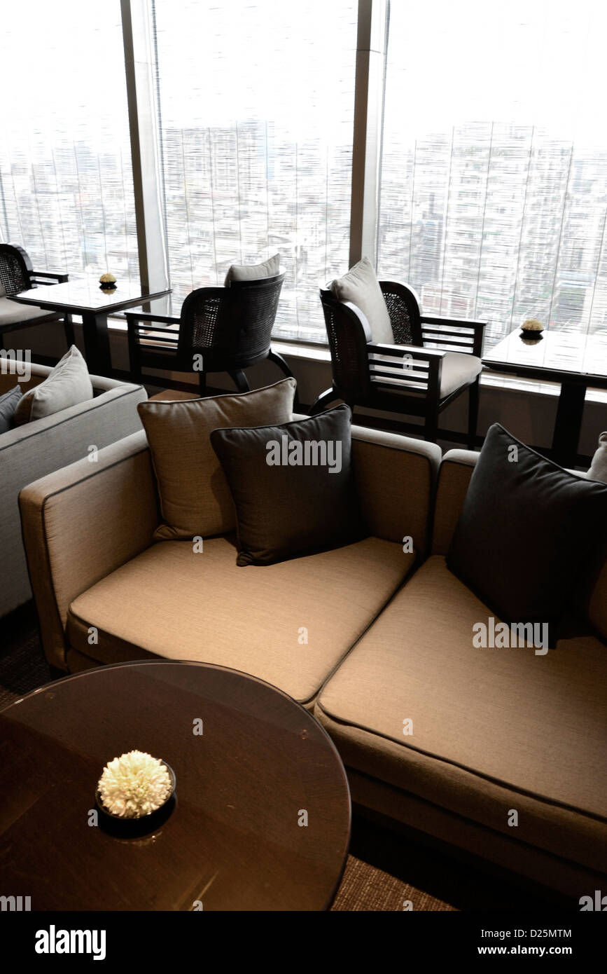 An interior view of hotel lounge with table and sofa viewing across the window towards the city of Taipie, Taiwan. Stock Photo
