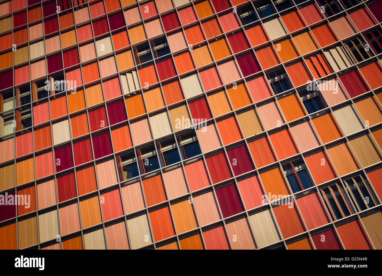 A patchwork of colourful blinds drawn across the windows of an office block in the centre of Berlin, Germany Stock Photo